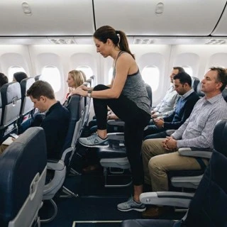 Woman stretching during flight to reduce joint stiffness