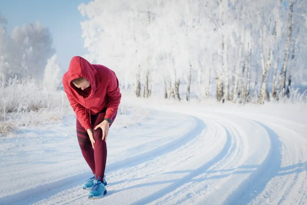 Traveller in cold weather holding her knee