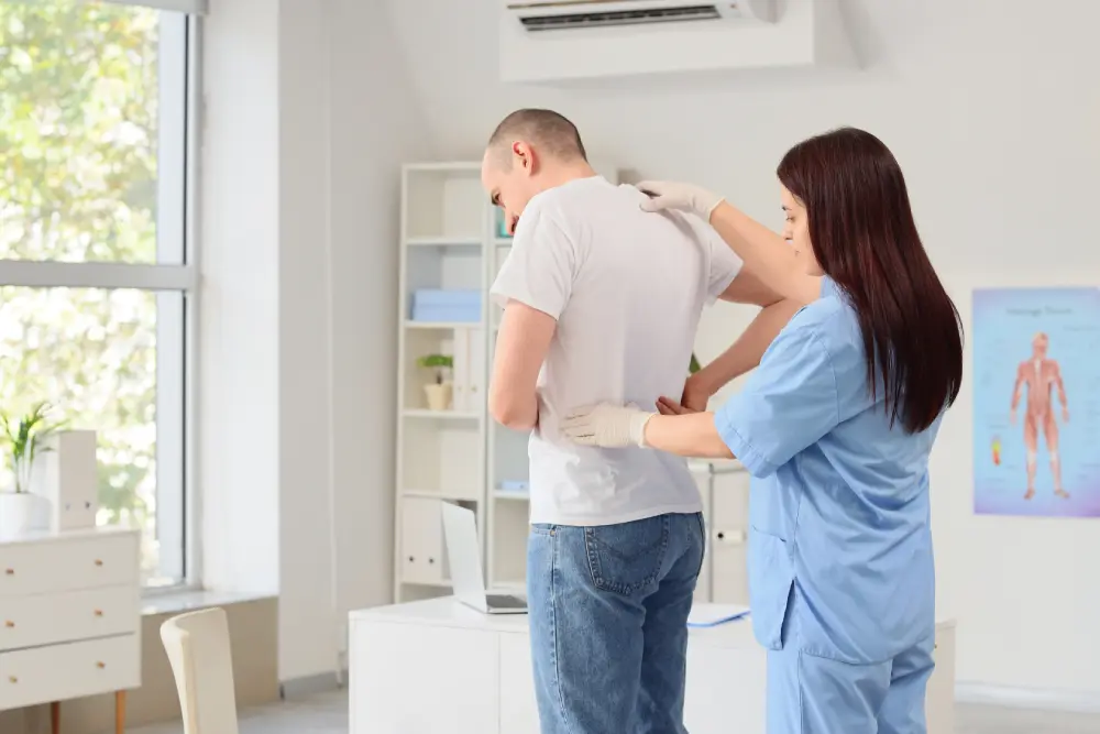 Doctor helping man with chronic back pain