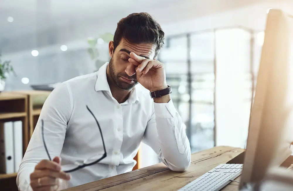 A man struggling with fatigue at the office
