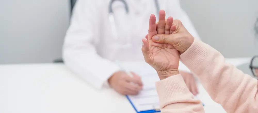 A person holding another's hand during a medical exam.